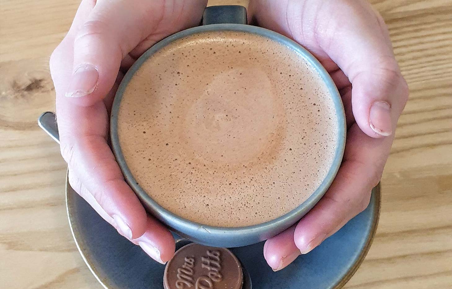 A person holding a hot chocolate