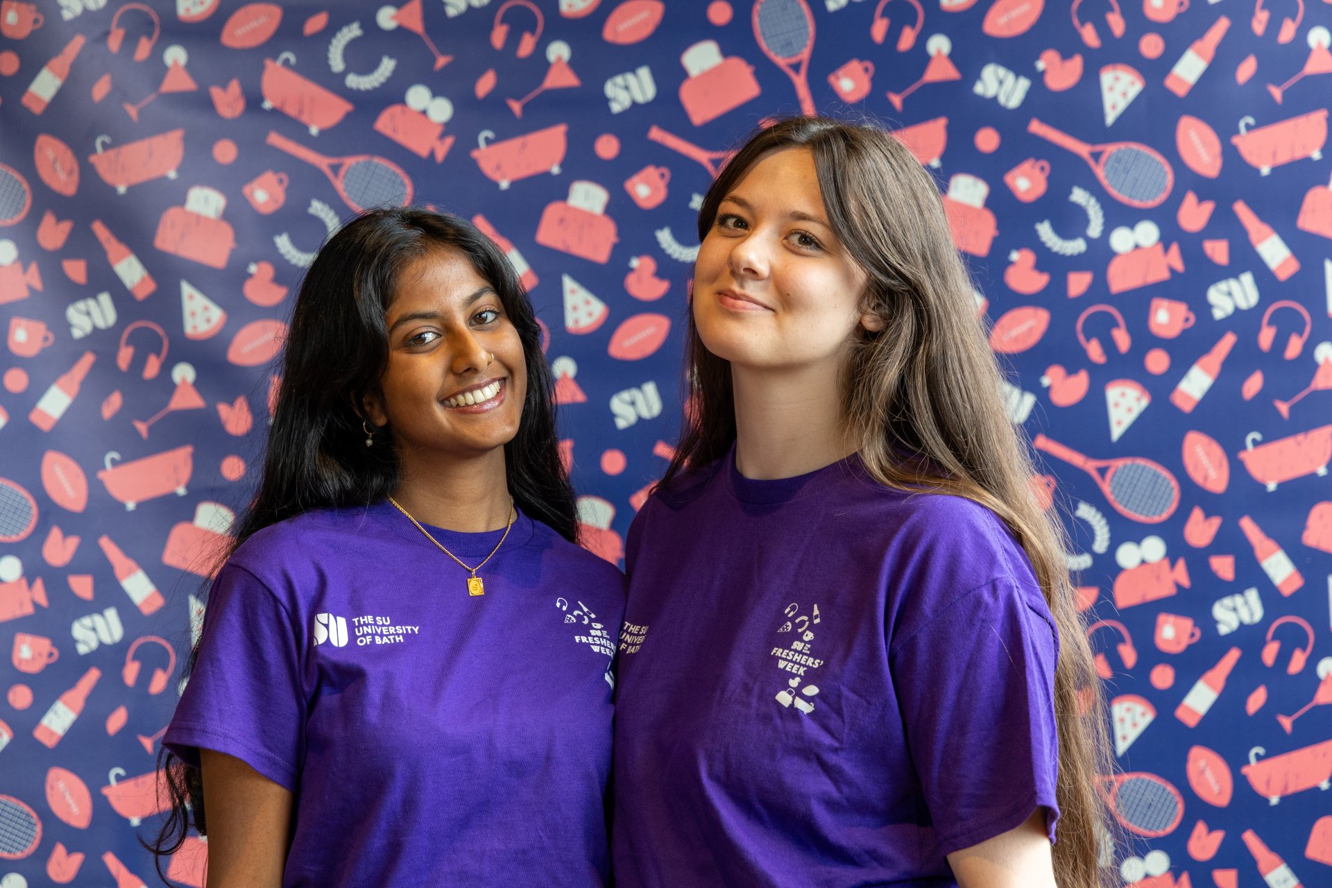 two freshers managers posing in front of a backdrop
