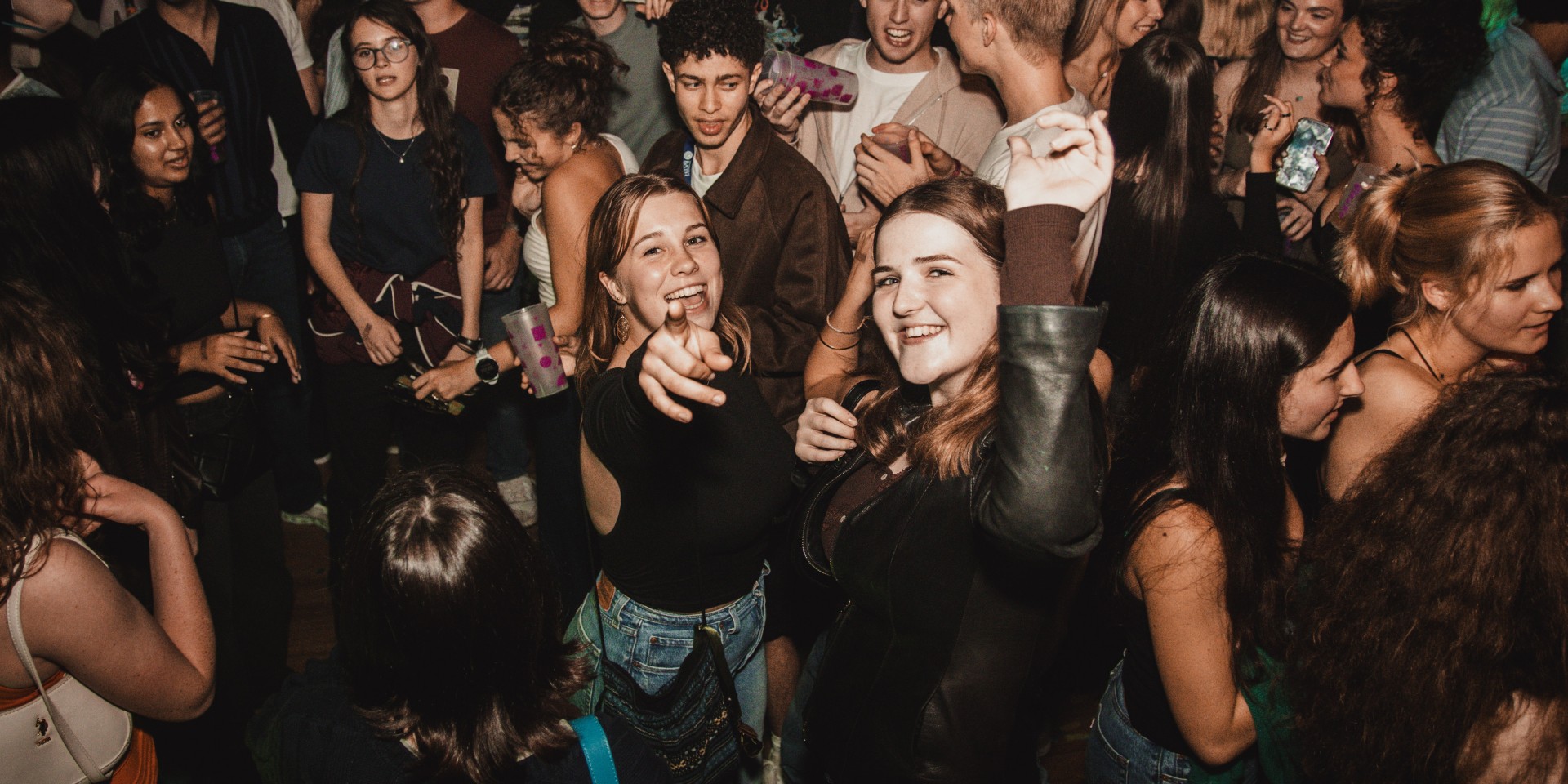 two girls pointing and dancing in night club