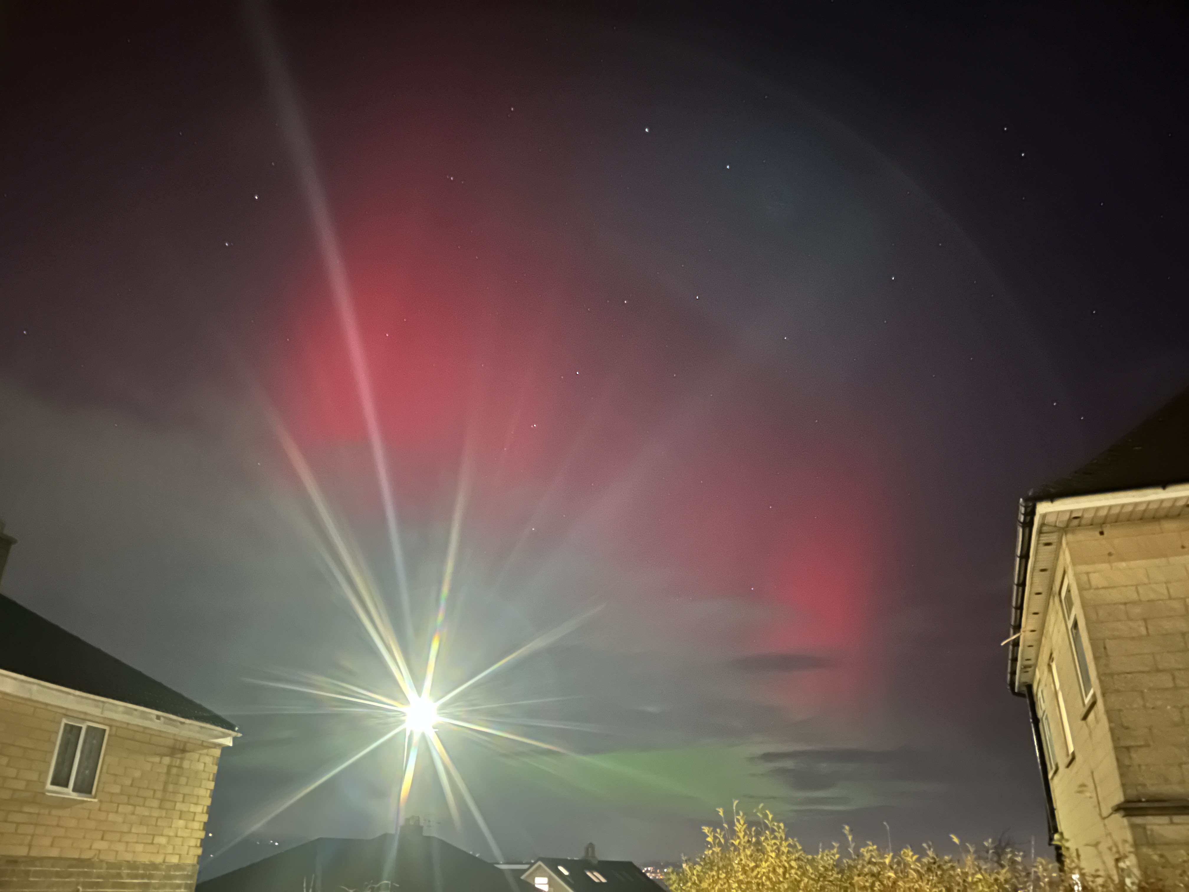 Photot of aurora in Bath city. A bright lamp post is in the foreground.