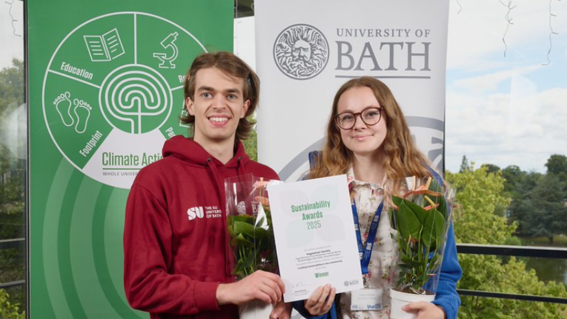 Two students posing with award