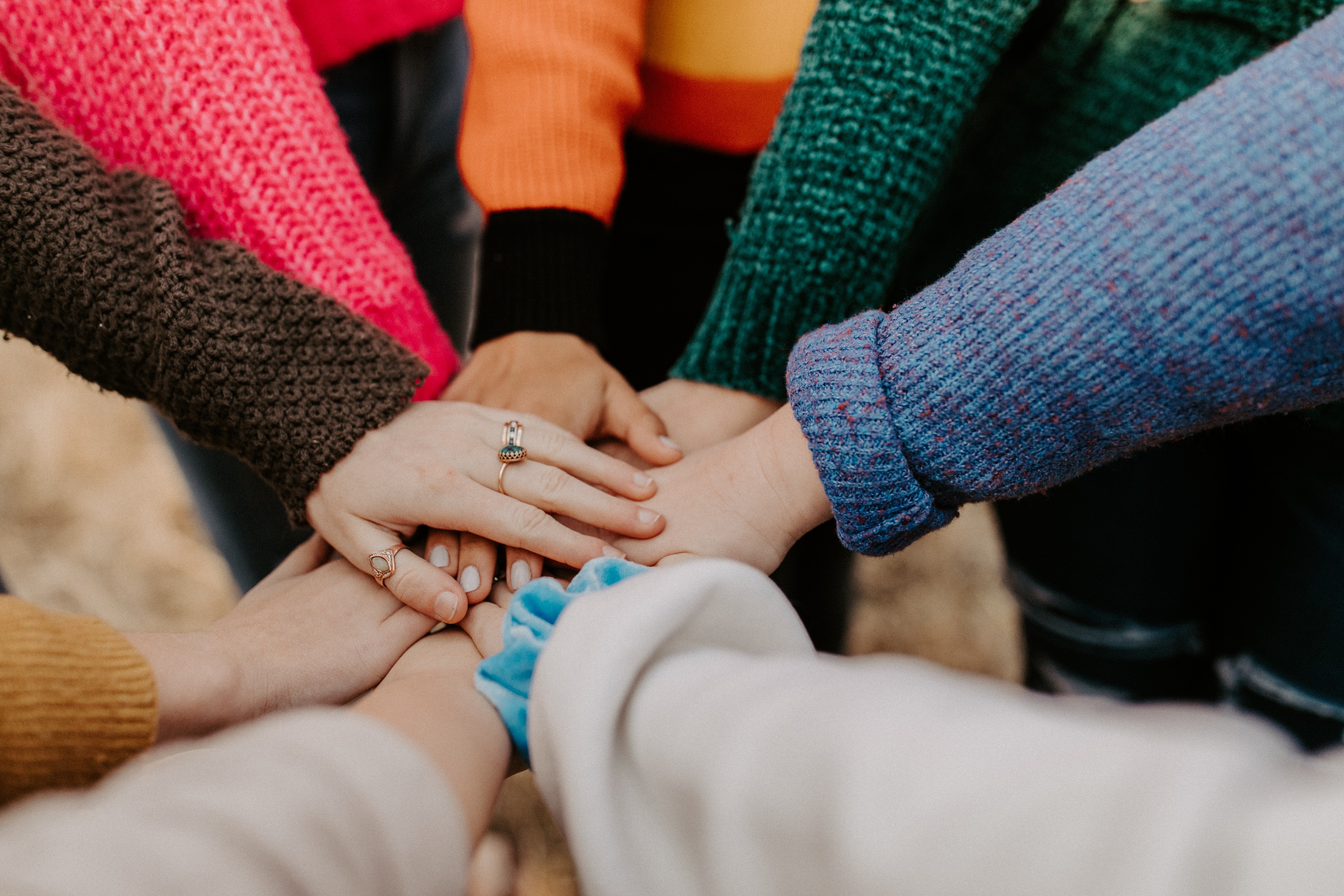 Students with hands in the middle of a gathering